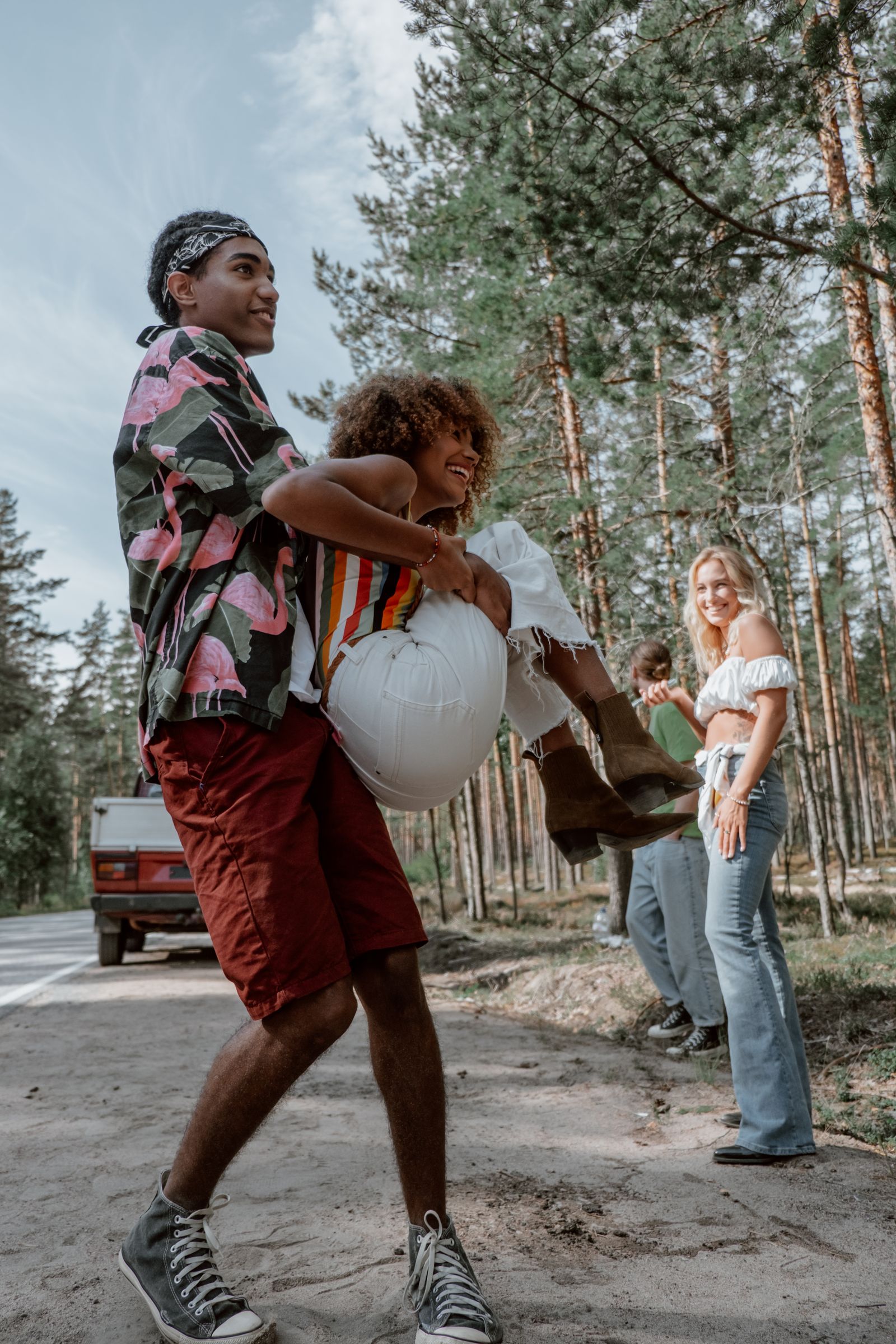 A group of diverse friends enjoying a playful moment outdoors in the forest.