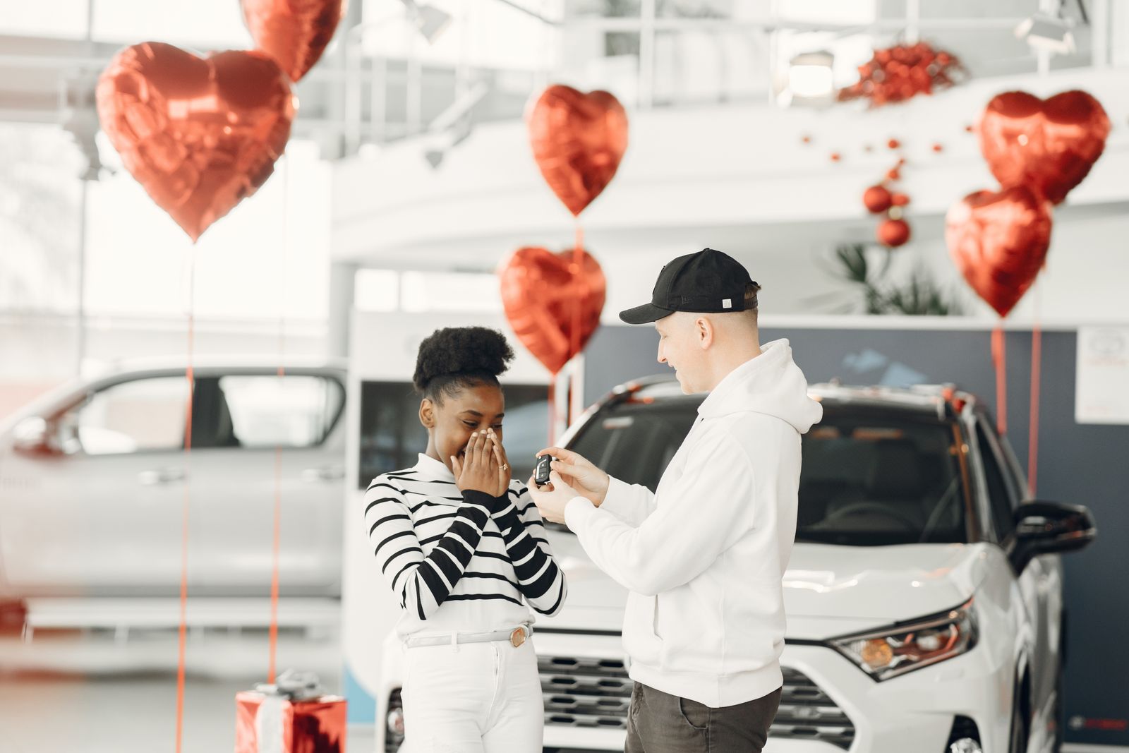Smiling couple sitting in their rental car holding the key